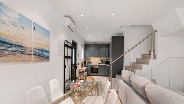 A modern interior with a dining area, kitchen, and staircase. - Villa Alvor Rooftop with Sea View, Wi-Fi and Air Conditioning (Alvor)