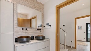 A modern bathroom with two sinks, a large mirror, and a wooden accent wall. - Villa Alvor Rooftop with Sea View, Wi-Fi and Air Conditioning (Alvor)