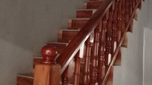 Una escalera de madera con barandilla que lleva a una plataforma.