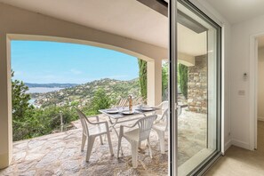 Un comedor con una mesa dispuesta para dos, con vistas a un paisaje costero.