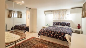 A bedroom with two beds, a mirror, a small table, and a red vase. - Charming 1-bedroom beautifully furnished apartment in quaint Roslyn w/Parking (Roslyn)