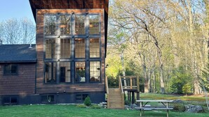 Un bâtiment moderne doté de grandes fenêtres et d’une terrasse en bois.