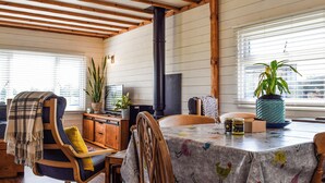 A cozy dining area with wooden beams, a fireplace, and a table with a colorful tablecloth. - 1 bedroom accommodation in Northampton (Northampton)