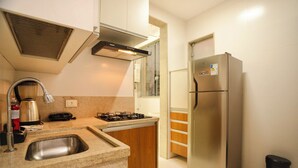 A modern kitchen with a stainless steel refrigerator, a gas stove, and a built-in sink.