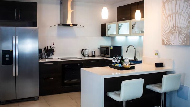 A modern kitchen with a central island, stainless steel appliances, and pendant lighting.