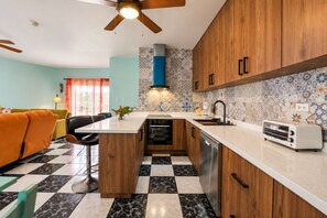 A compact kitchen with wooden cabinets, a central island, and a checkered floor.