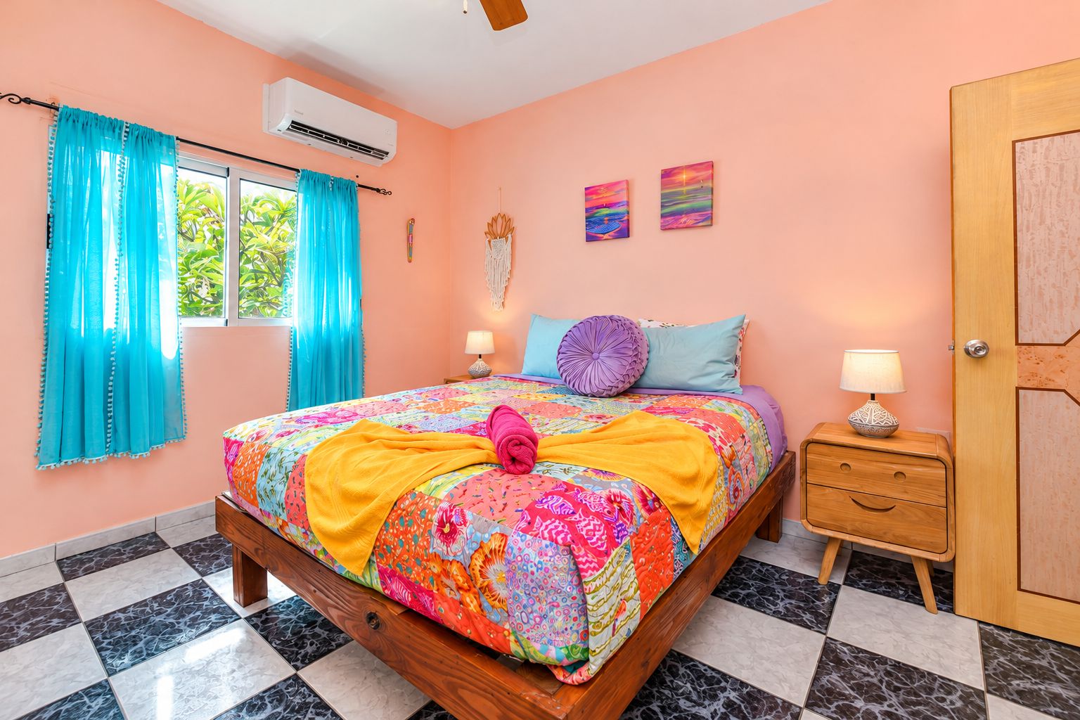 A bedroom with a bed, a nightstand, a door, and a window with curtains.