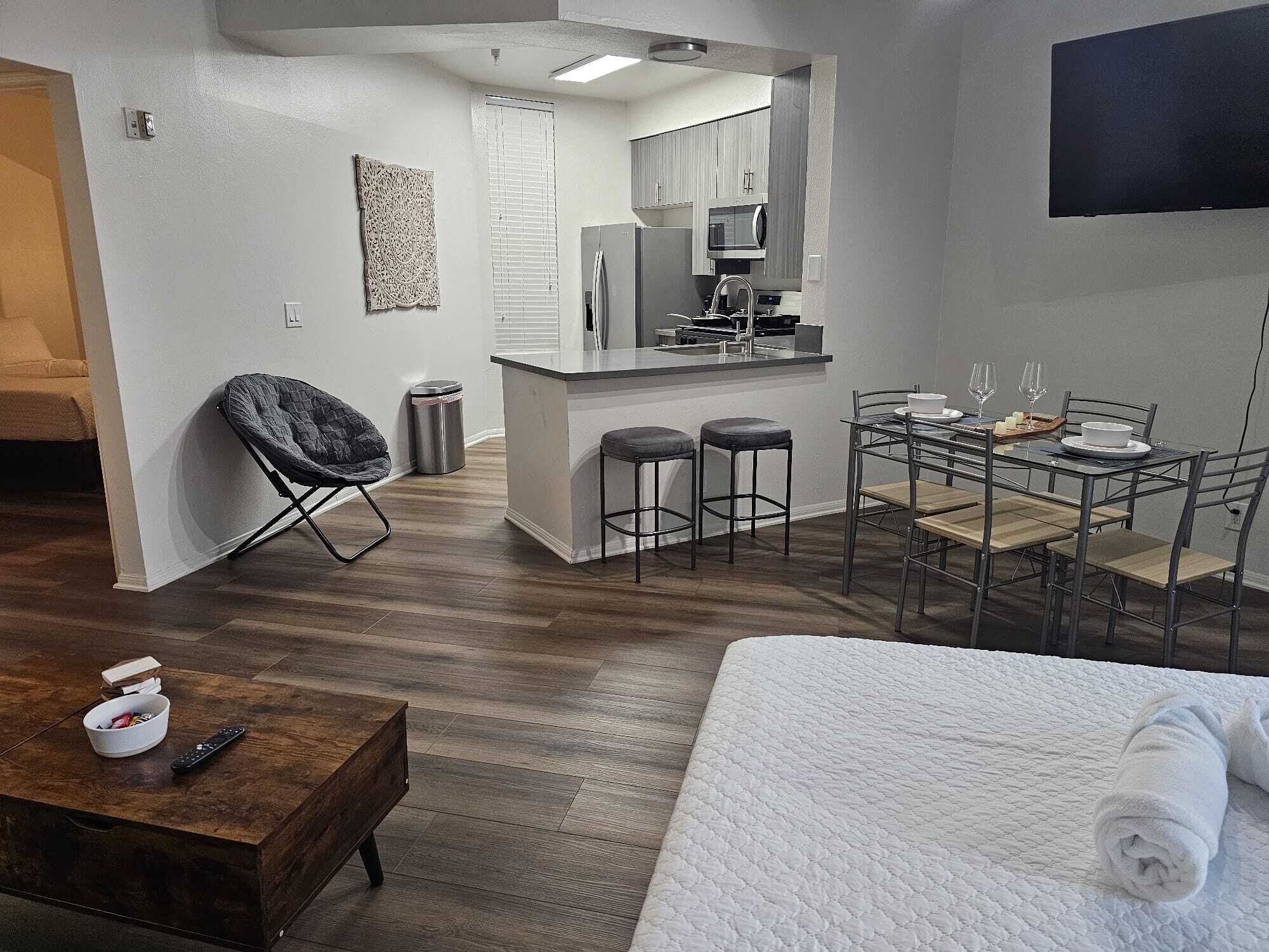 Ein kompaktes Hotelzimmer mit Küchenzeile, Essbereich und Bett.