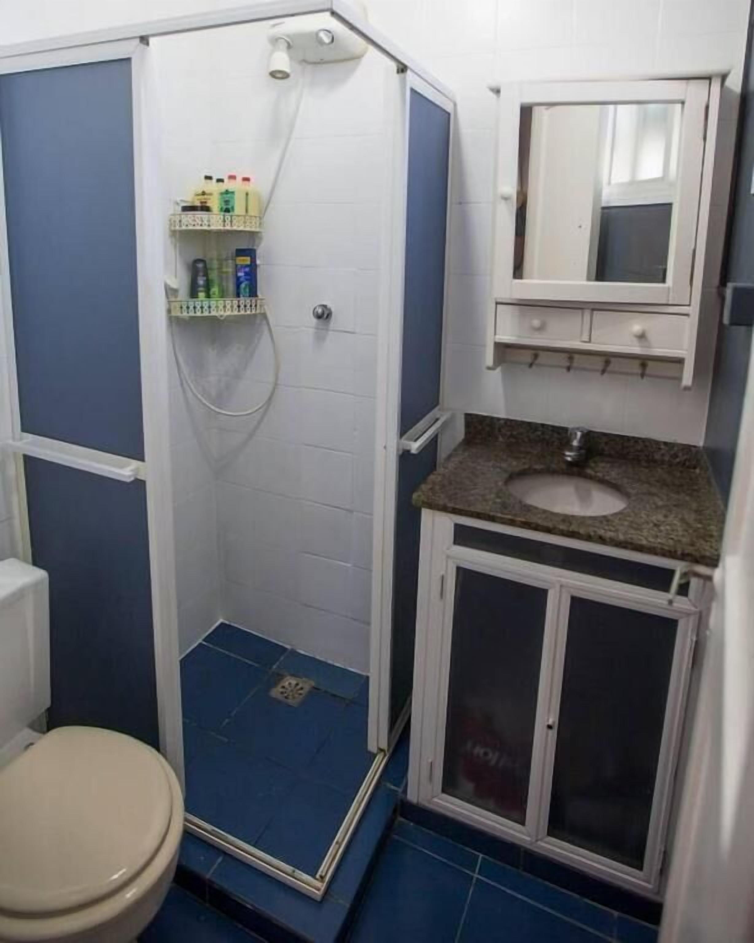 Une salle de bain équipée d’une douche, de toilettes, d’un lavabo et d’un meuble avec miroir.