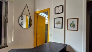 A room with a black countertop, a yellow door, a wall clock, and framed pictures. - SUH Copacabana 89 Beach View (Rio de Janeiro)