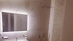 A bathroom with a white sink, a mirror, and a shower enclosure. - Hotel Noel (Vlorë)