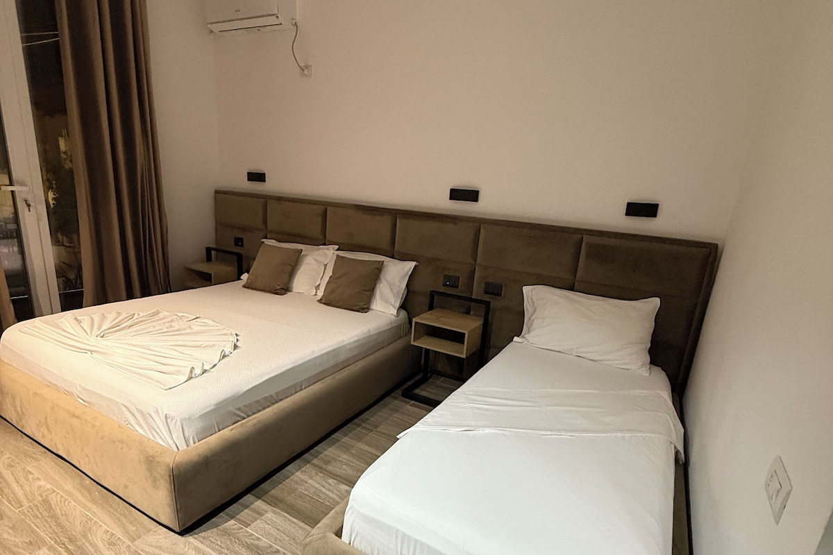 Een slaapkamer met twee bedden, een garderobe en een schuifglazen deur.