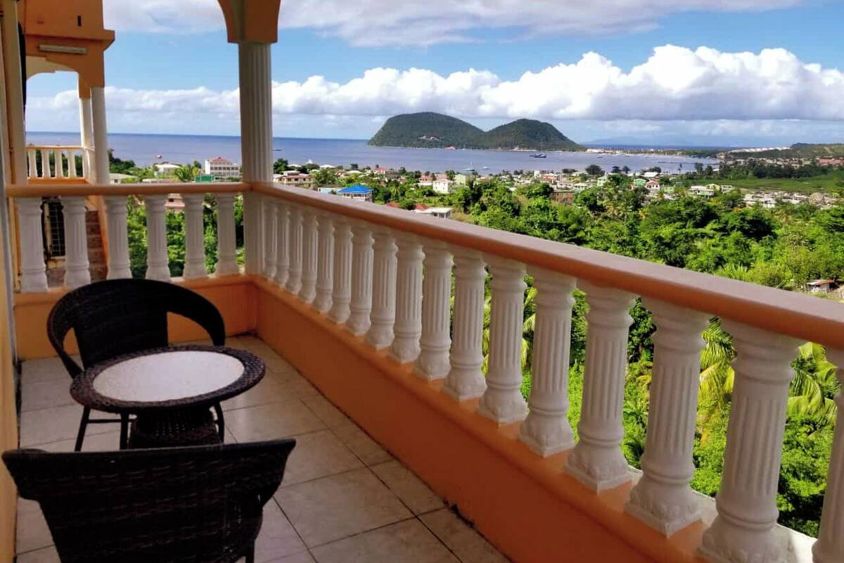Un balcon avec vue sur la mer et une île lointaine.