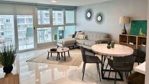 A modern living room with a sofa, a round table, and a coffee table.