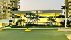 A hotel named 'CORAL BEACH' with a central courtyard, surrounded by high-rise buildings.