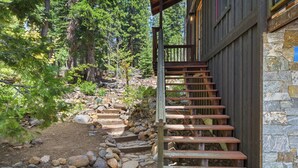 A wooden staircase leading to a stone building surrounded by trees. - Kingswood Luxury Home with Hot Tub, Backs to Forest (Kings Beach)