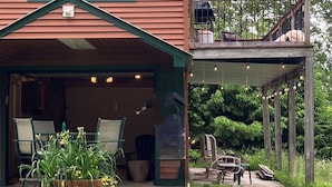 Een huis met twee verdiepingen, een overdekte veranda en een terras.