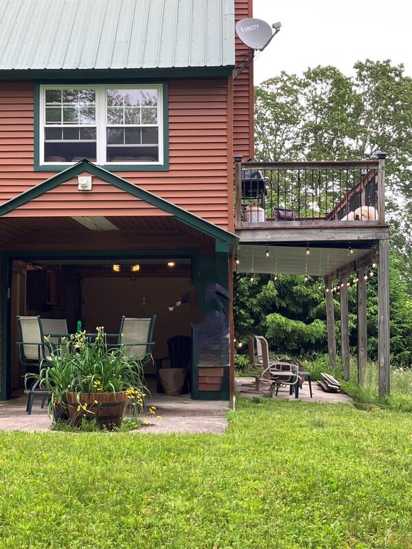 A two-story house with a covered porch and a deck.