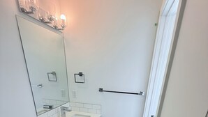 Une salle de bain moderne avec des toilettes, un lavabo et un miroir.