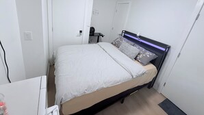 Une chambre à coucher avec un lit, une table de chevet et une porte.