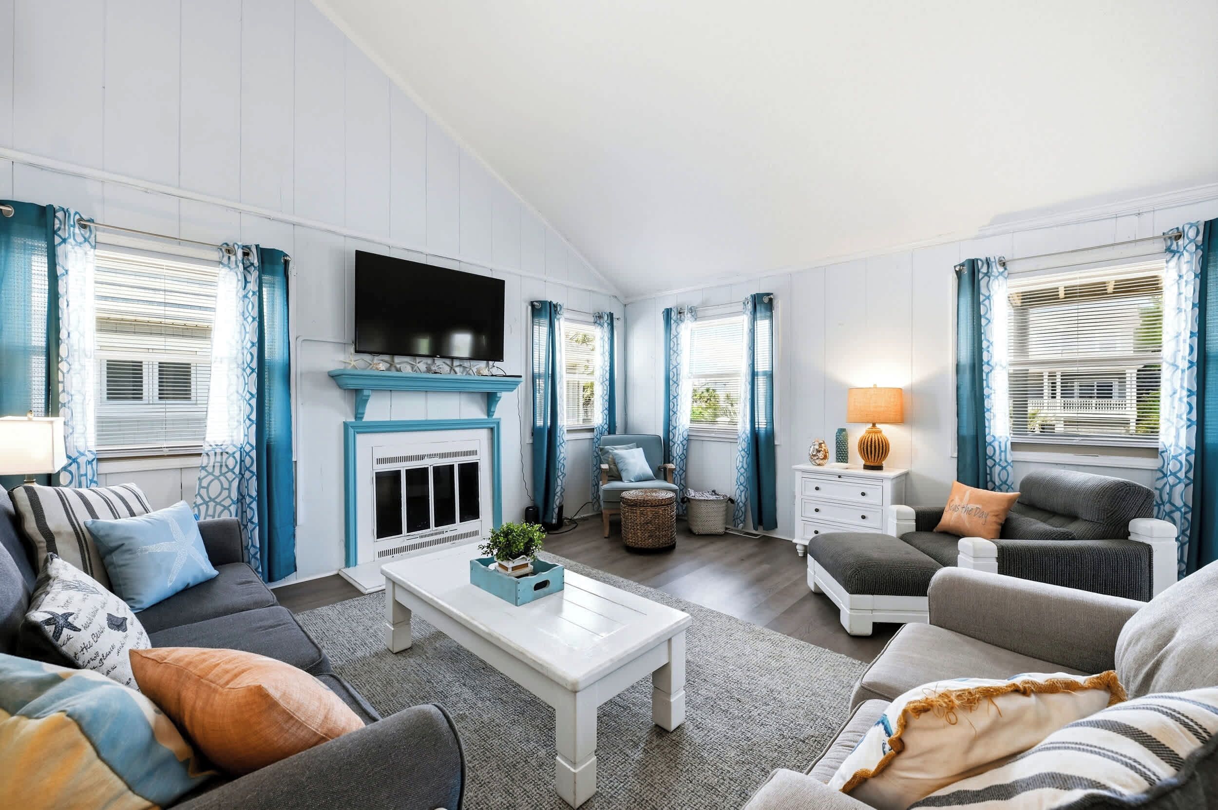 Ein Wohnzimmer mit Kamin, Sofas, einem Couchtisch und einem Fernseher.