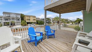 A wooden deck with blue chairs, a white railing, and a view of neighboring houses. - The Salty Rooster by Brunswick Vacation Rentals: New Pool & Renovated Bedrooms (Ocean Isle Beach)