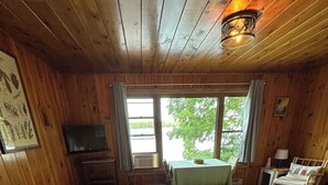 Une chambre dans un chalet en bois, équipée de deux lits, d’une télévision, d’une table et d’une chaise.