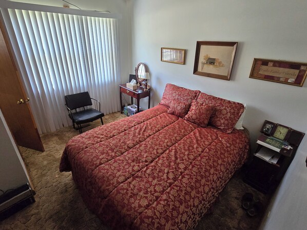 A bedroom with a large bed, a desk with a mirror, and a framed picture on the wall. - 3-bedroom house in charming Stanton with AC, WiFi. Book now (Stanton)