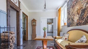 Una sala de estar acogedora con un sofá de madera, una mesa de centro y un cuadro grande en la pared.