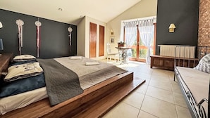 Une chambre moderne avec un grand lit, une petite table et une vue sur l’extérieur.