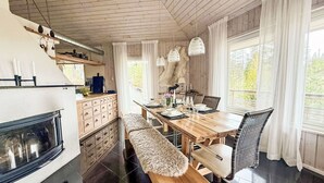 Een moderne keuken met een inbouwfornuis, houten kastjes en een eethoek met een bank en tafel.