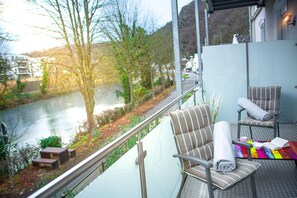 A balcony with two chairs, a small table, and a colorful blanket. - Stunning 2- Bedroom Apartment with Breathtaking River Views in Bad Ems (Bad Ems)