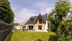 Ein Haus mit Steinaußenwand, geneigtem Dach und einem Balkon.