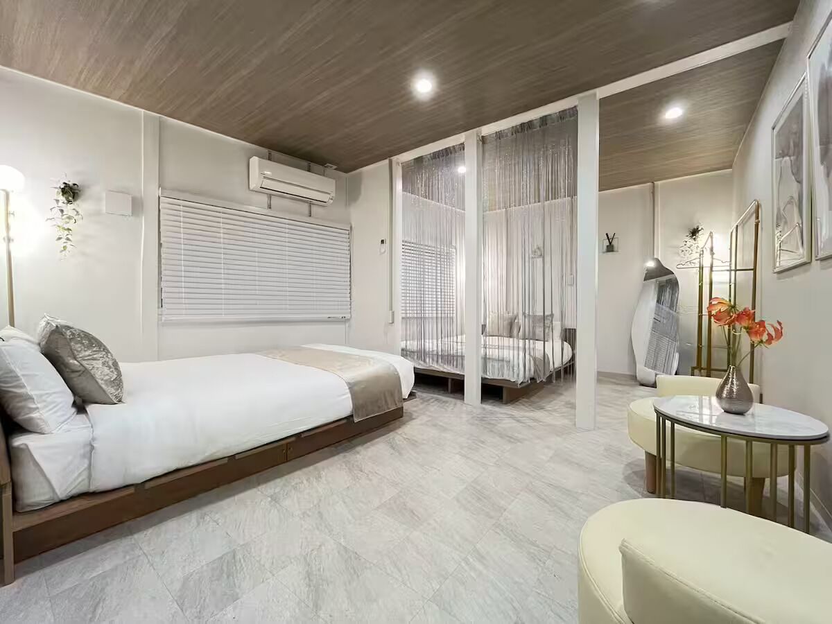 Un dormitorio moderno con una cama, una mesita y una silla.