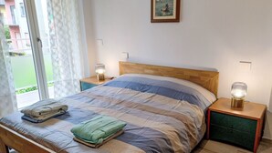 A bedroom with a bed, two bedside tables with lamps, a window with curtains, and a painting on the wall. - Camelia by Interhome (Verbania)