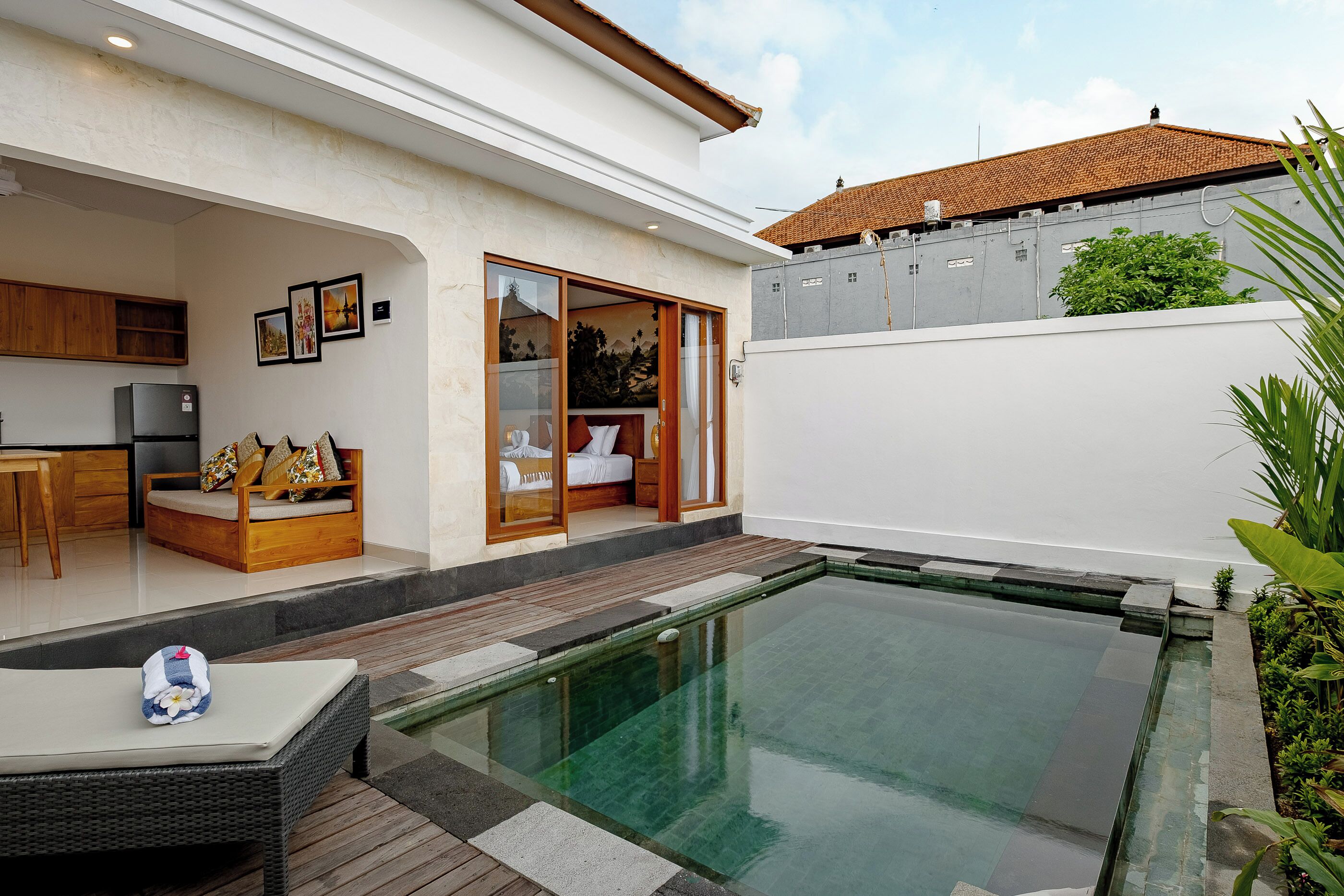 Une maison moderne dotée d’une piscine, d’une cuisine et d’un espace de vie comprenant un canapé et une table à manger.