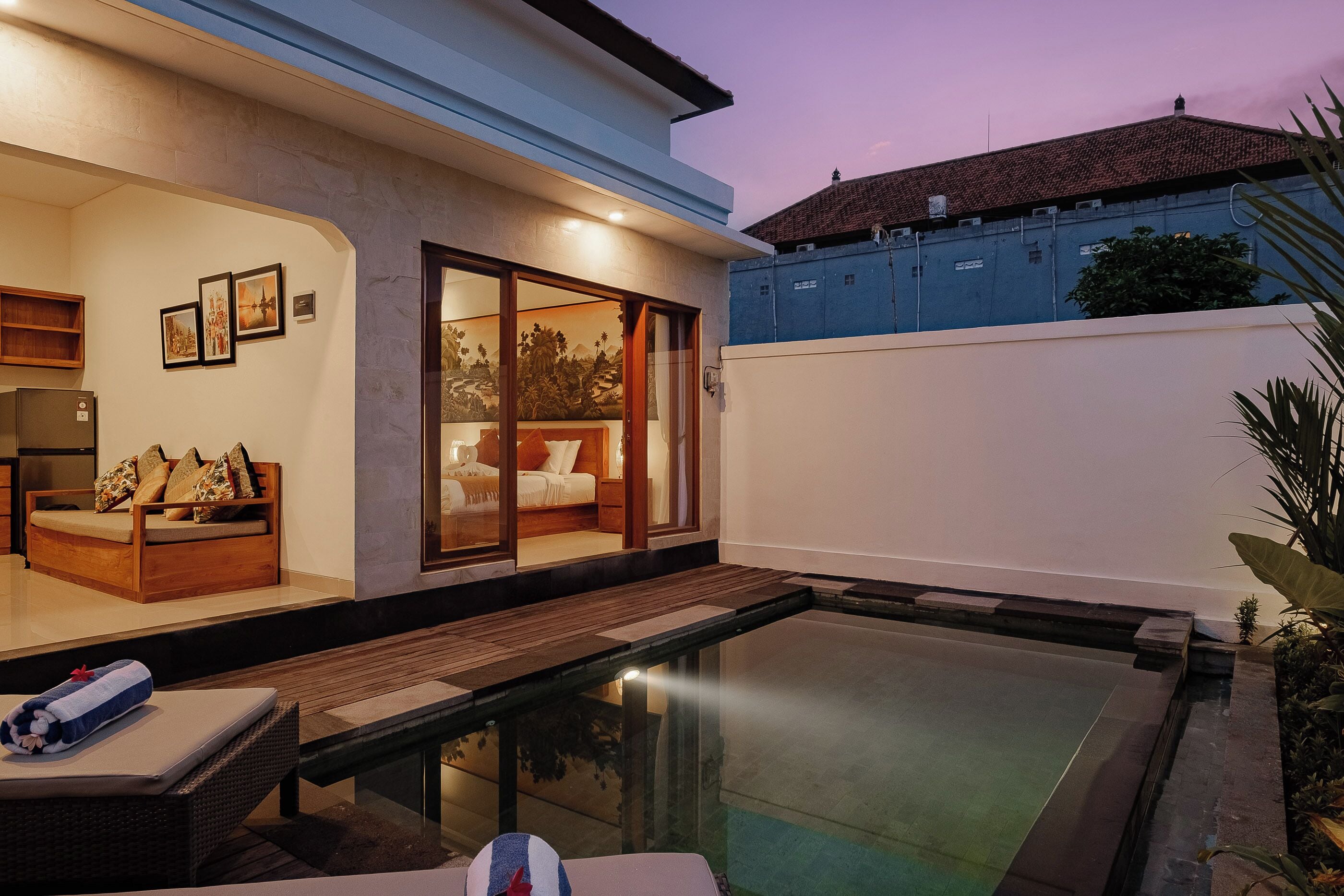 A modern house with a swimming pool, a wooden deck, and a glass-enclosed bedroom.
