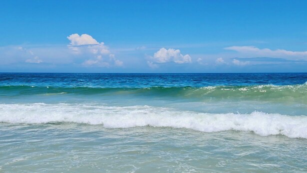 Una playa con olas y un cielo despejado.