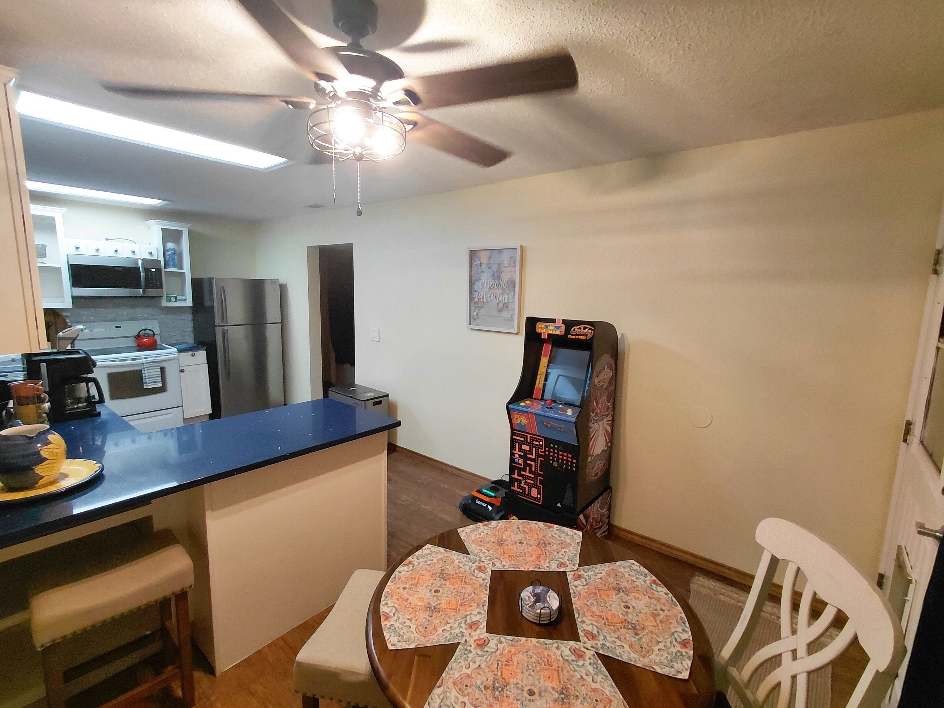 Una cocina equipada con microondas, refrigerador y ventilador de techo.