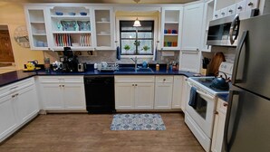 A modern kitchen with white cabinets, a blue countertop, a dishwasher, a stove, and a refrigerator. - Unique A-Frame wloft, pool, & RV electric 17 min from Silver Springs State Park  (Silver Springs)