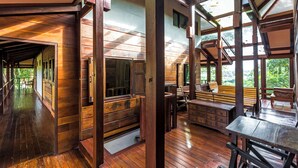 Una cabaña de madera espaciosa con un amplio espacio abierto, una mesa de comedor y una banca.