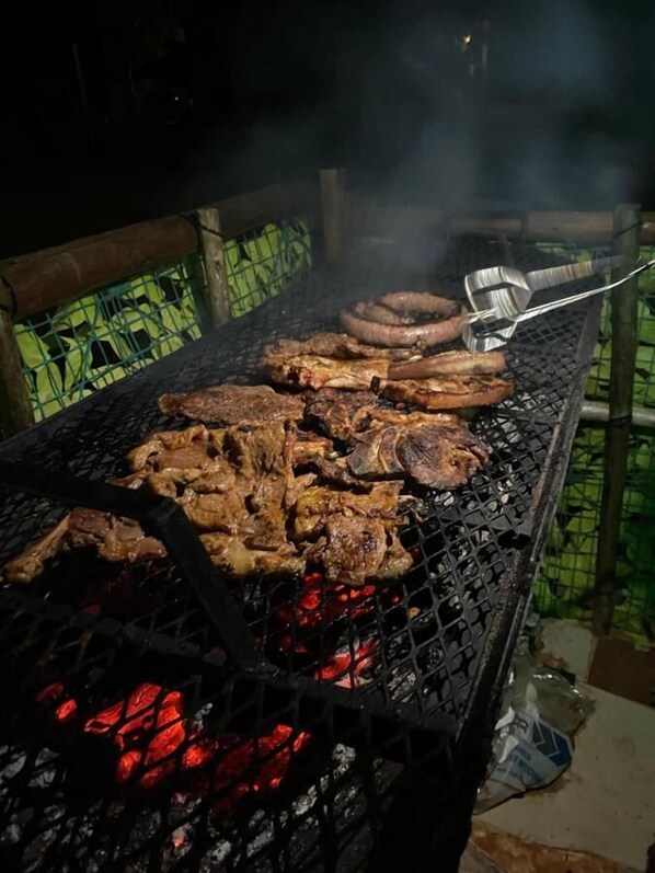 A grill with various meats being cooked.