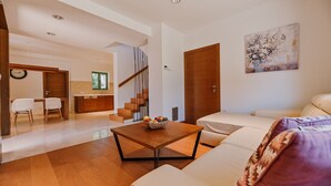 Una sala moderna con un sofá, una mesa de centro y una escalera que lleva a una cocina.