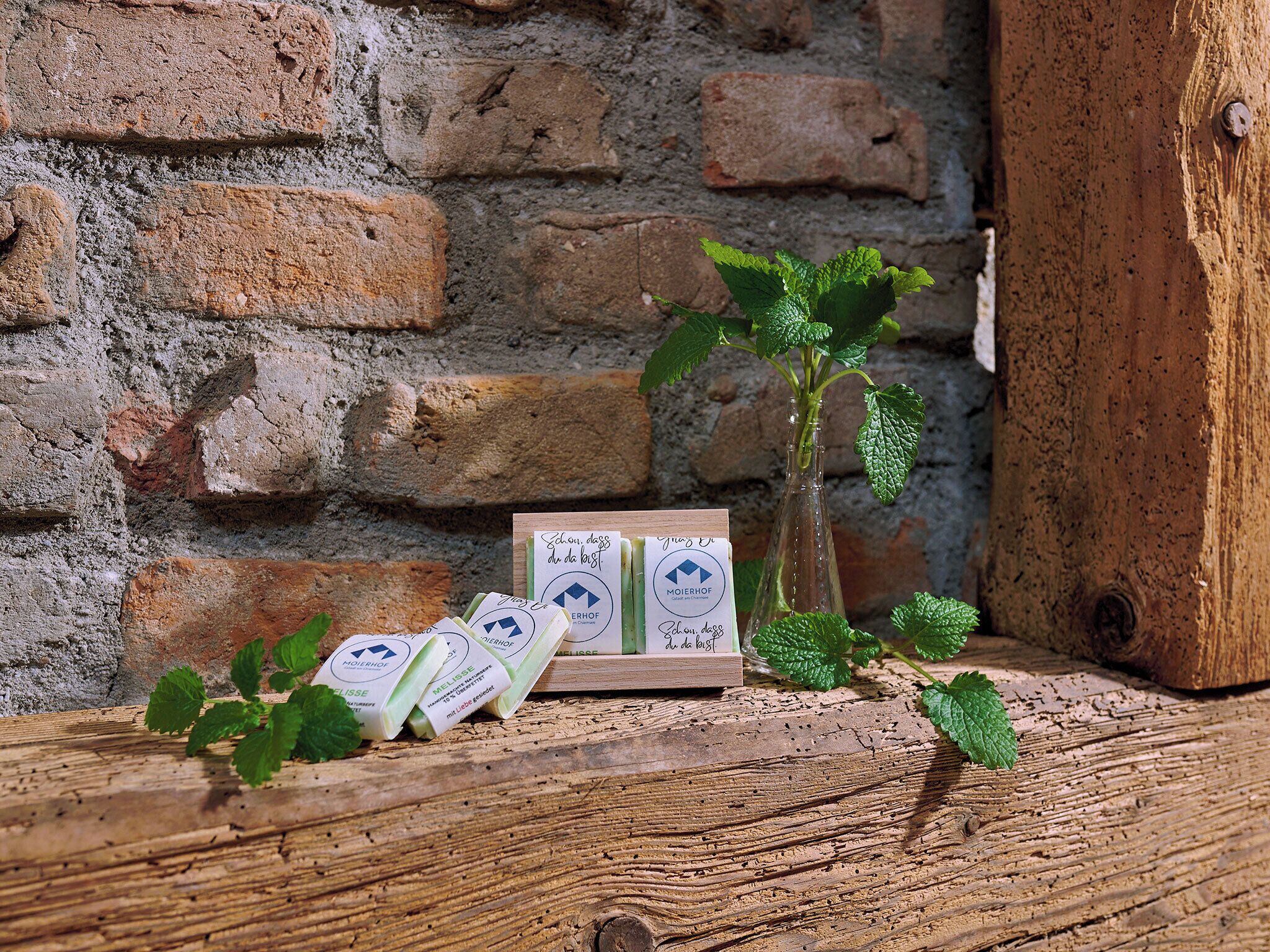 Une table en bois rustique, sur laquelle se trouvent une bouteille en verre et un porte-cartes contenant des cartes.