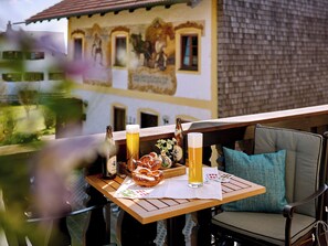 Una mesa con una botella de cerveza, un vaso de cerveza, pretzels y una silla de playa con cojín.