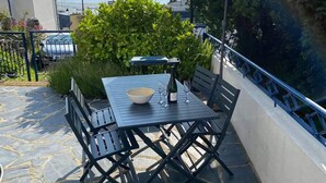 A patio with a table and chairs, a bottle of wine, and a bowl. - Charm and nature in Morlaix Bay, sea view and coastal path (Plouezoc'h)