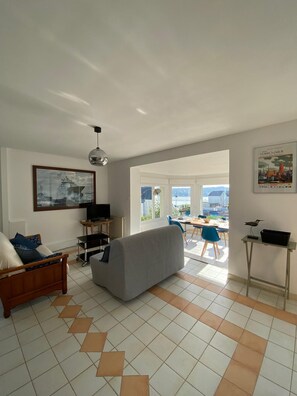 Relax in this spacious living area with a comfortable sofa, wooden-framed bed, and dining table.