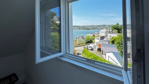 A room with a large window offering a view of a coastal town and the sea. - Charm and nature in Morlaix Bay, sea view and coastal path (Plouezoc'h)