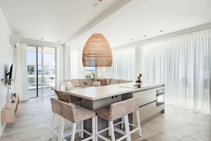 Enjoy cooking in this kitchen with a central island, bar stools, and a view of the outdoors through sliding glass doors.