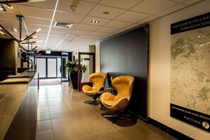 Welcome to our lobby, featuring a sleek reception desk, comfortable seating, and a map to help you navigate your stay.